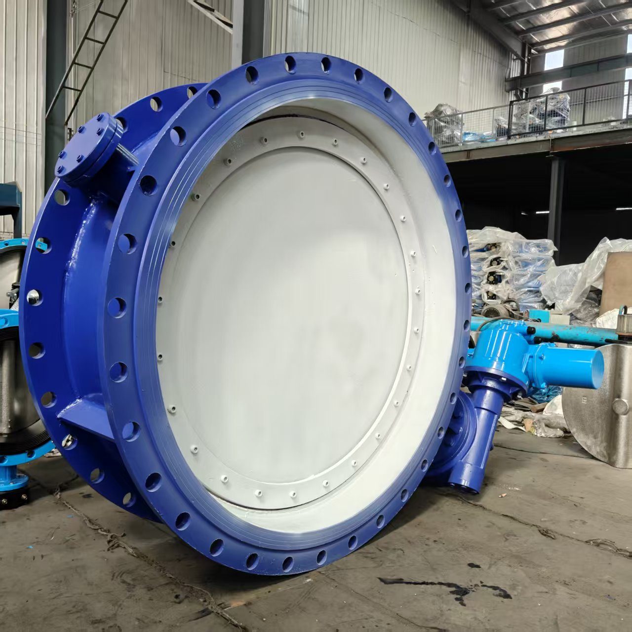 Electric flanged butterfly valve disc detail with workshop background